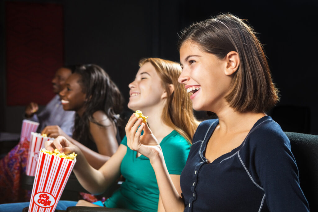 Young teens watching movie together in theater