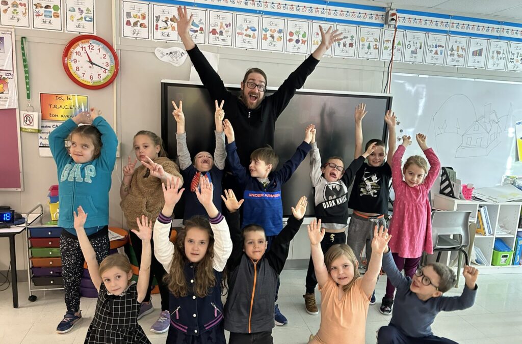 Un artiste et des élèves prennent la pose dans un contexte d'art et interdisciplinarité à l'école.