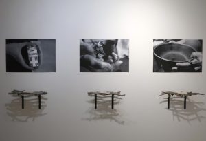 Cours 8 art et interdisciplinarité Photo de l’exposition, résidence de Maillardville (2020) 3 photos en noir et blanc alignées, chacune représentant des mains tenant un objet. Sous chaque photo une sorte d'étagère de petites branches.